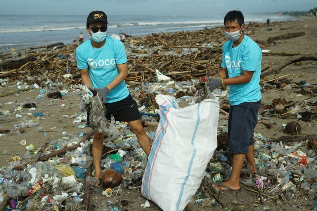 Waste collectors standing amid discarded materials, illustrating the challenge of waste management. Not a photograph of the Sungai Lestari programme.