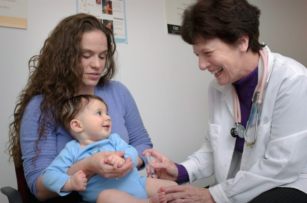 Healthcare professional administering a childhood vaccine in a clinical setting; illustrative photograph.
